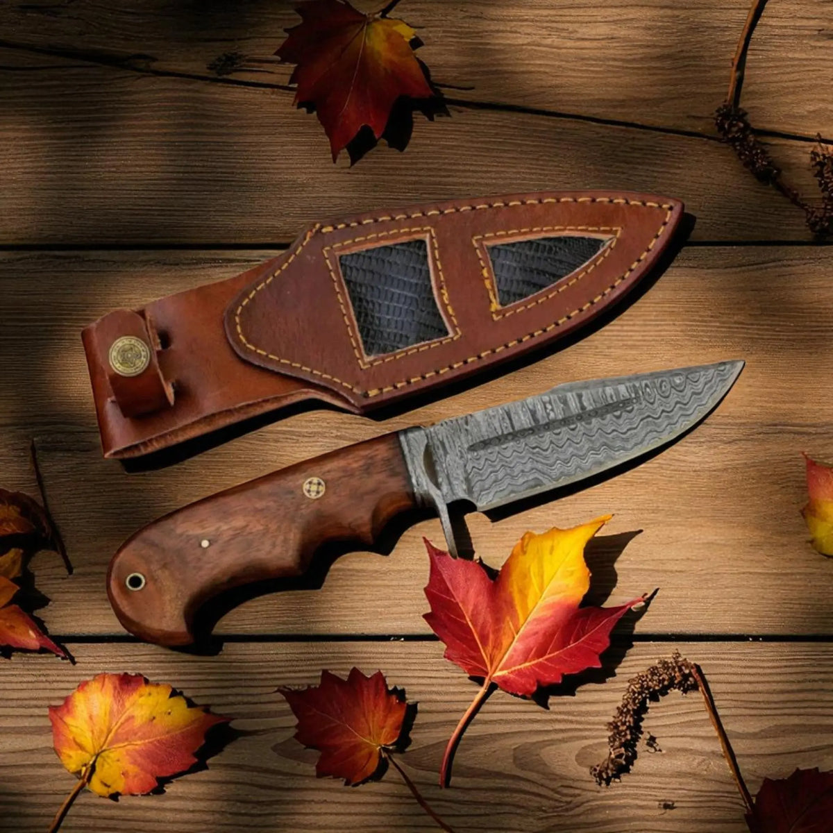 Bobcat Knife with Damascus Steel Blade, Rosewood Handle, and Leather Sheath on a rustic background
