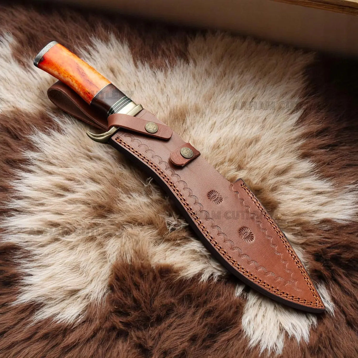 Handmade Damascus Bowie knife with orange camel bone, rosewood handle, and brass guard on sheepskin surface – Arham Cutlery