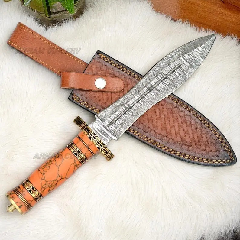 Damascus Steel Bowie Knife with Orange Turquoise and Brass Handle and Leather Sheath on White Fur Background