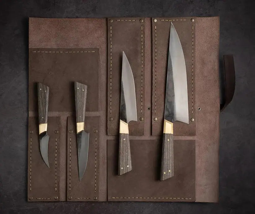 A set of four kitchen knives with dark wood handles and silver blades, displayed inside an open brown leather roll-up case on a dark textured background.