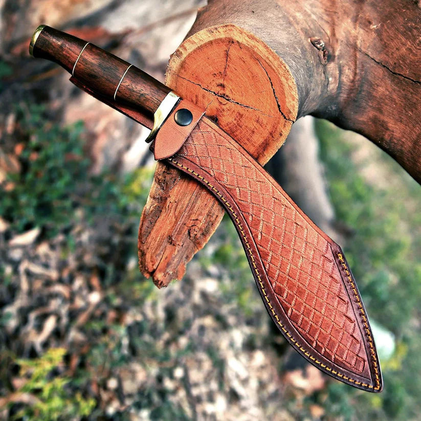 A fixed-blade knife with a dark wood handle and a brown leather sheath, shown resting against a cut log outdoors with a blurred natural background.