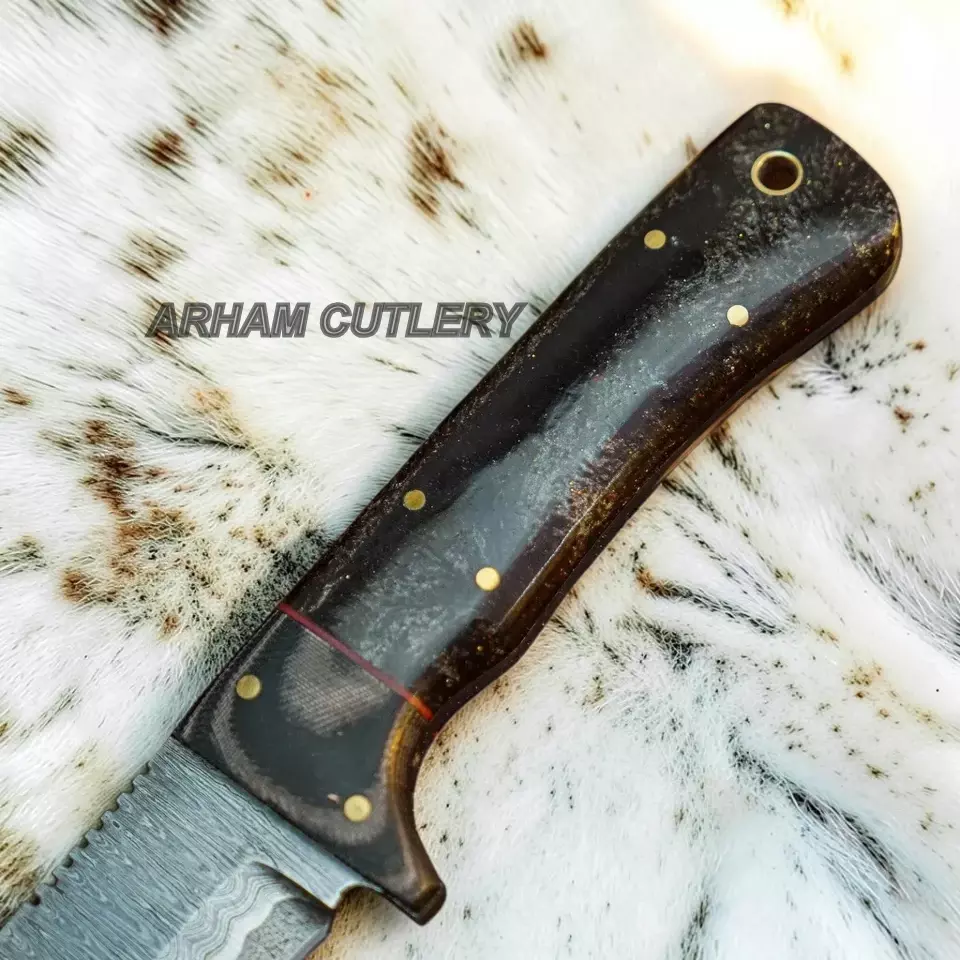 A close-up of a knife handle made of dark wood with brass pins, resting on a white and brown animal hide background. The brand name 'ARHAM CUTLERY' is watermarked across the center.