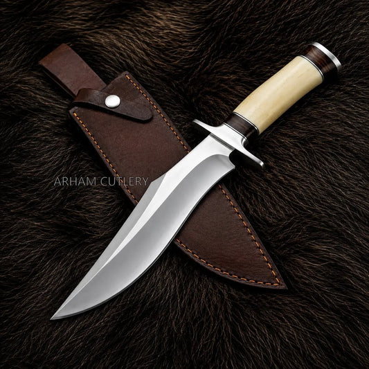 A fixed-blade hunting knife with a polished steel blade, cream-colored handle, and dark brown leather sheath, displayed diagonally on a dark brown fur background. The brand name 'ARHAM CUTLERY' is watermarked across the center.
