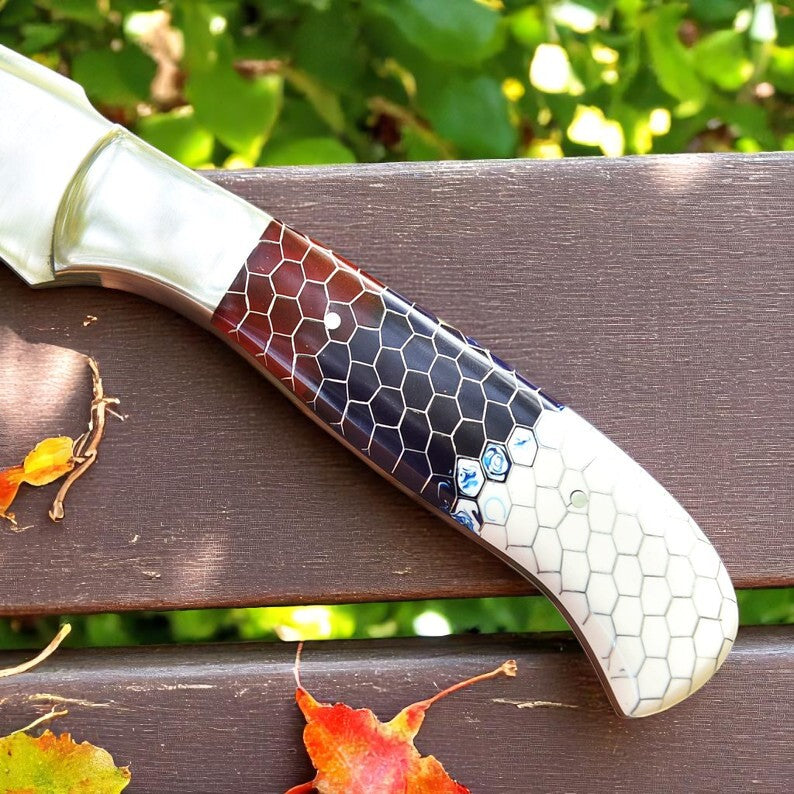 Handcrafted D2 steel knife with colorful honeycomb resin handle held outdoors – Arham Cutlery
