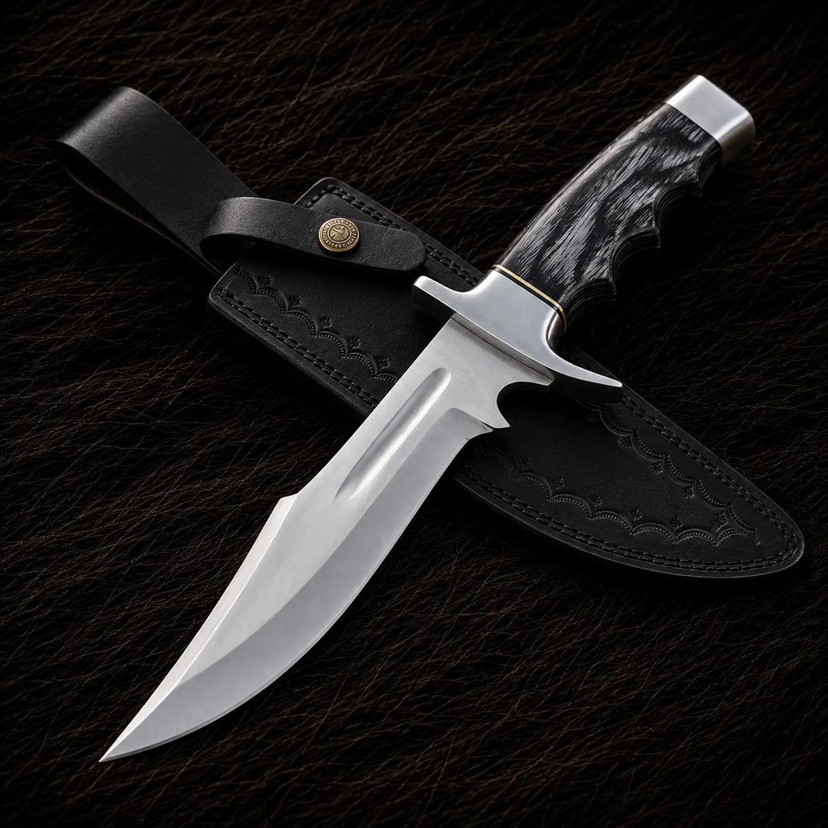 A fixed-blade knife with a polished silver blade, textured black handle, and silver-toned guard, shown resting on a black leather sheath against a dark textured background.