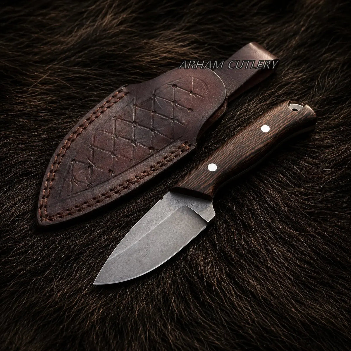 A fixed-blade knife with a dark wood handle and steel blade lies next to its stitched brown leather sheath on a dark brown fur background. The text 'ARHAM CUTLERY' is visible near the sheath.