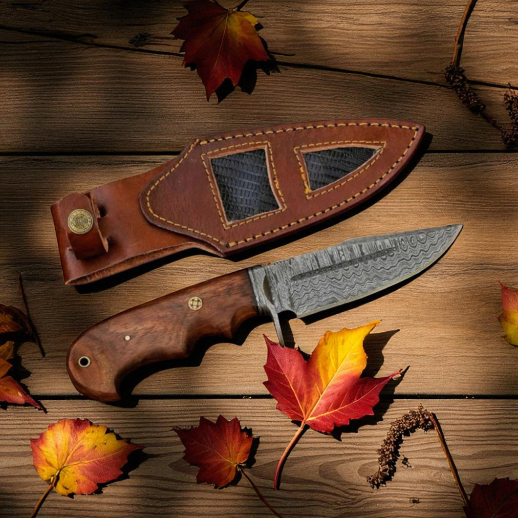 Bobcat Knife with Damascus Steel Blade, Rosewood Handle, and Leather Sheath on a rustic background