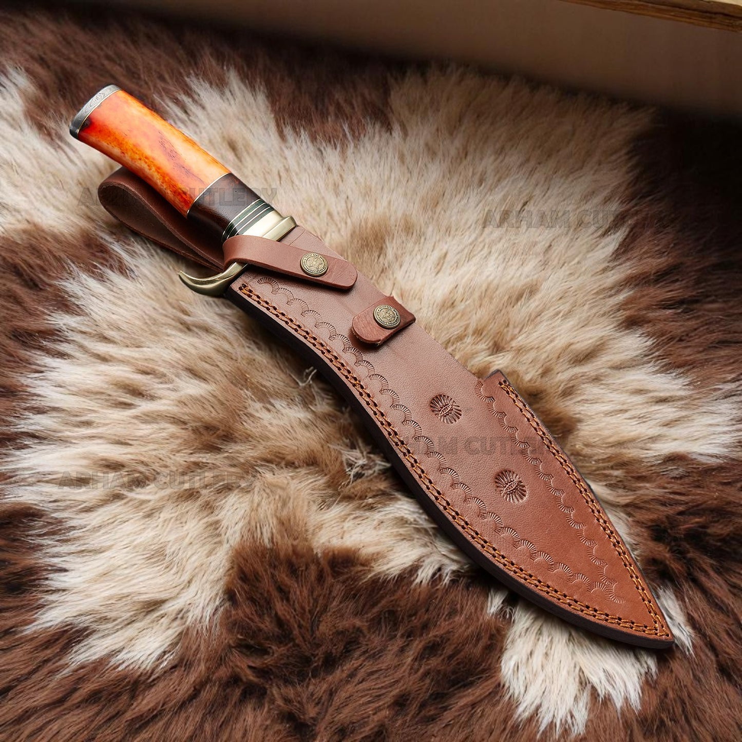 Handmade Damascus Bowie knife with orange camel bone, rosewood handle, and brass guard on sheepskin surface – Arham Cutlery
