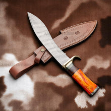 Lade das Bild in den Galerie-Viewer, Handmade Damascus Bowie knife with orange camel bone, rosewood handle, and brass guard on sheepskin surface – Arham Cutlery
