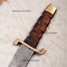 Cargar imagen en el visor de la galería, Hand-forged Damascus steel short sword with wooden handle and brass accents by Arham Cutlery, displayed on a wooden surface
