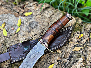 Steelroot – 13-Inch Damascus Steel Hunting Knife with Rosewood and Brass Handle, displayed on bark with handmade leather sheath – Arham Cutlery