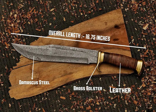 A fixed-blade knife with a patterned Damascus steel blade, brass bolster, and brown leather handle, displayed on a piece of wood over a dark textured background with wood shavings. White text labels identify the materials and show the overall length as 16.