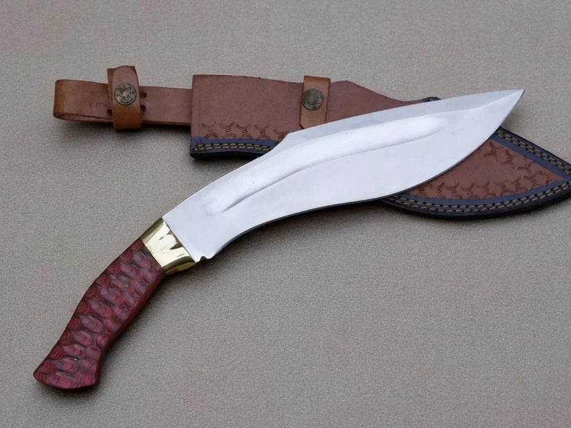 A curved fixed-blade knife with a polished silver blade, a gold-toned bolster, and a reddish-brown textured handle, shown with a brown leather sheath on a neutral gray background.