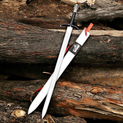 A silver-colored sword with a black wrapped handle and a matching white sheath with red accents, displayed diagonally on a rustic background of weathered logs.