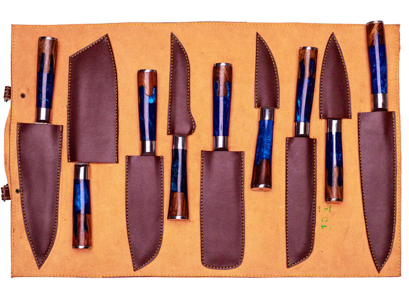 A set of kitchen knives with blue and brown marbled resin handles, displayed in a tan leather roll-up case with matching brown sheaths.