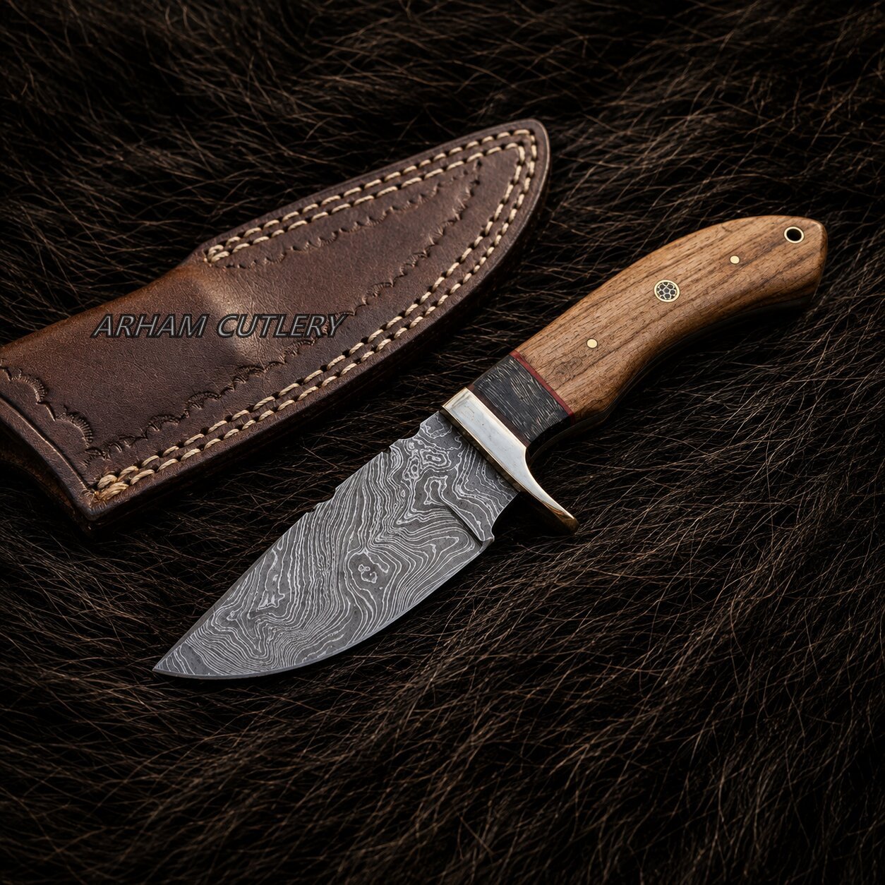 A fixed-blade knife with a patterned Damascus-style steel blade and a wooden handle, displayed next to a brown leather sheath on a dark fur background. The brand name 'ARHAM CUTLERY' is printed on the sheath.