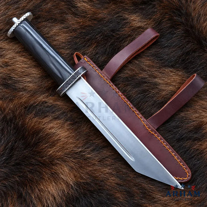 A fixed-blade knife with a polished silver blade, black handle, and silver guard, displayed diagonally next to its brown leather sheath on a brown fur background.