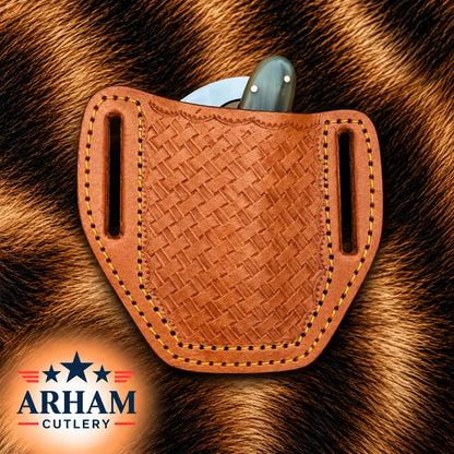 A tan woven leather knife sheath with side cutouts, shown holding a knife on a brown fur background. The ARHAM CUTLERY logo appears in the lower-left corner.