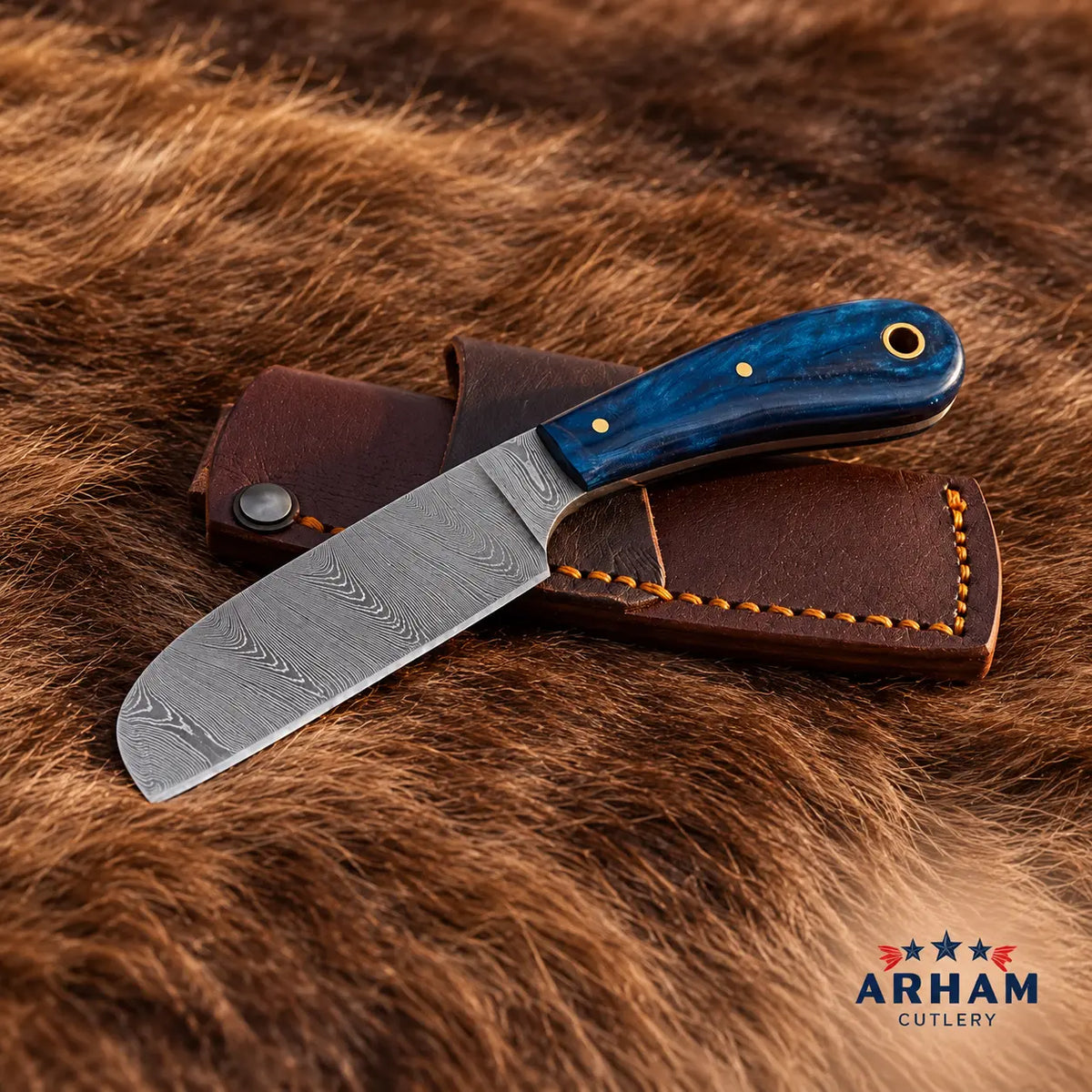 A fixed-blade knife with a patterned steel blade and a blue marbled handle, resting on a brown leather sheath over a brown fur background. The ARHAM CUTLERY logo is visible in the bottom right corner.