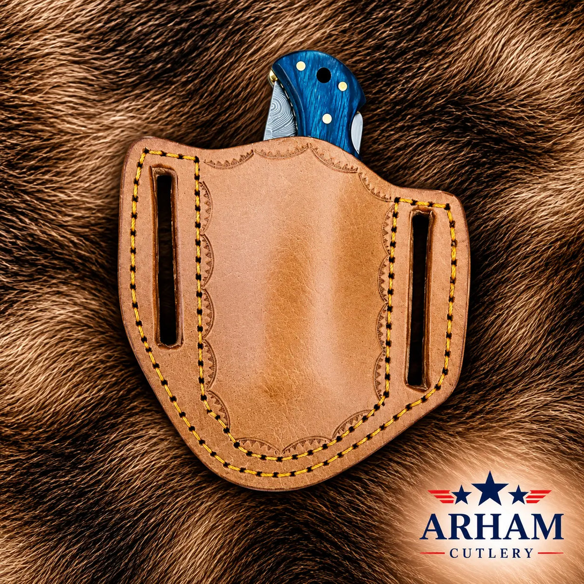 A tan leather knife sheath with decorative stitching and side slots, holding a folding knife with a blue handle, placed on a brown fur background. The ARHAM CUTLERY logo is visible in the bottom right corner.