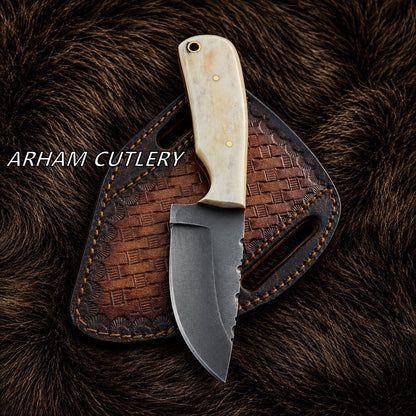 A fixed-blade knife with a dark steel blade and an ivory-colored handle rests on a brown embossed leather sheath, set against a dark brown fur background. The text 'ARHAM CUTLERY' is overlaid on the left side.