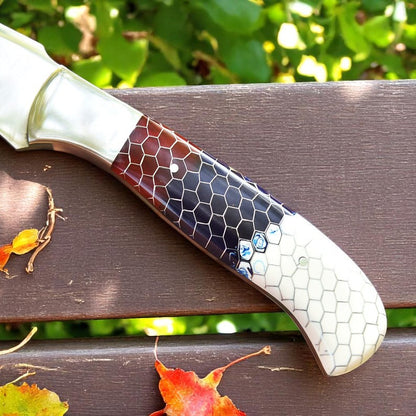 Handcrafted D2 steel knife with colorful honeycomb resin handle held outdoors – Arham Cutlery