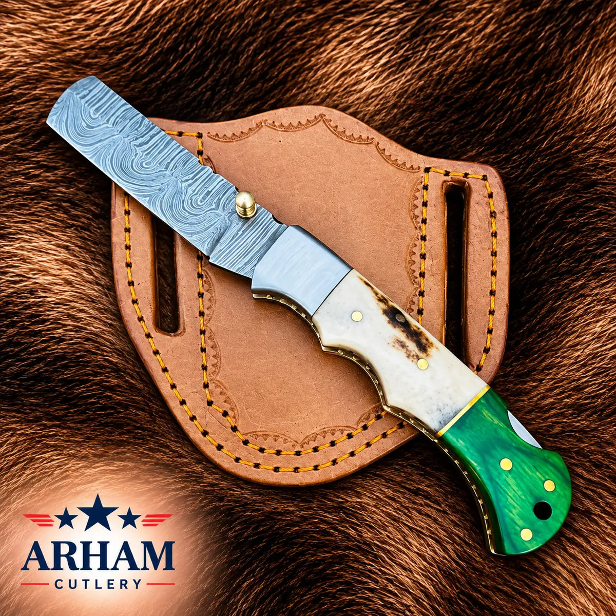 A folding pocket knife with a patterned Damascus steel blade, a bone handle, and a green wood handle is displayed diagonally on a brown leather sheath over a brown fur background. The ARHAM CUTLERY logo is visible in the bottom-left corner.