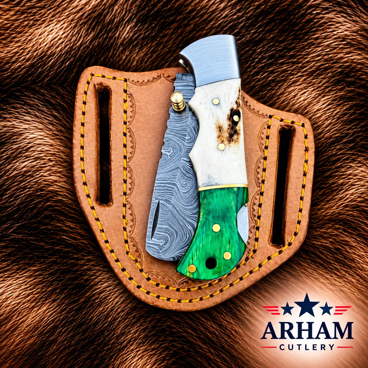 A folding pocket knife with a Damascus steel blade, white bone handle, and green inlay, displayed in a brown leather sheath on a brown fur background. The Arham Cutlery logo is visible in the bottom right corner.