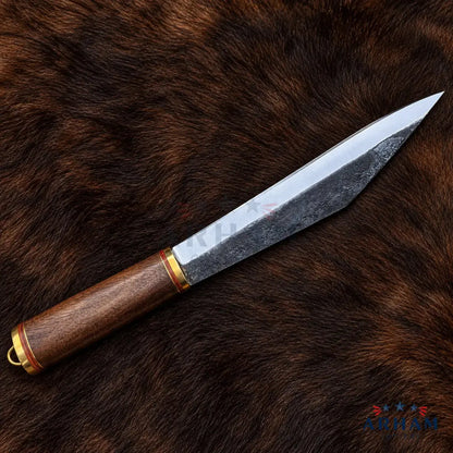 A fixed-blade knife with a textured steel blade and a brown wooden handle, displayed diagonally on a dark brown fur background.