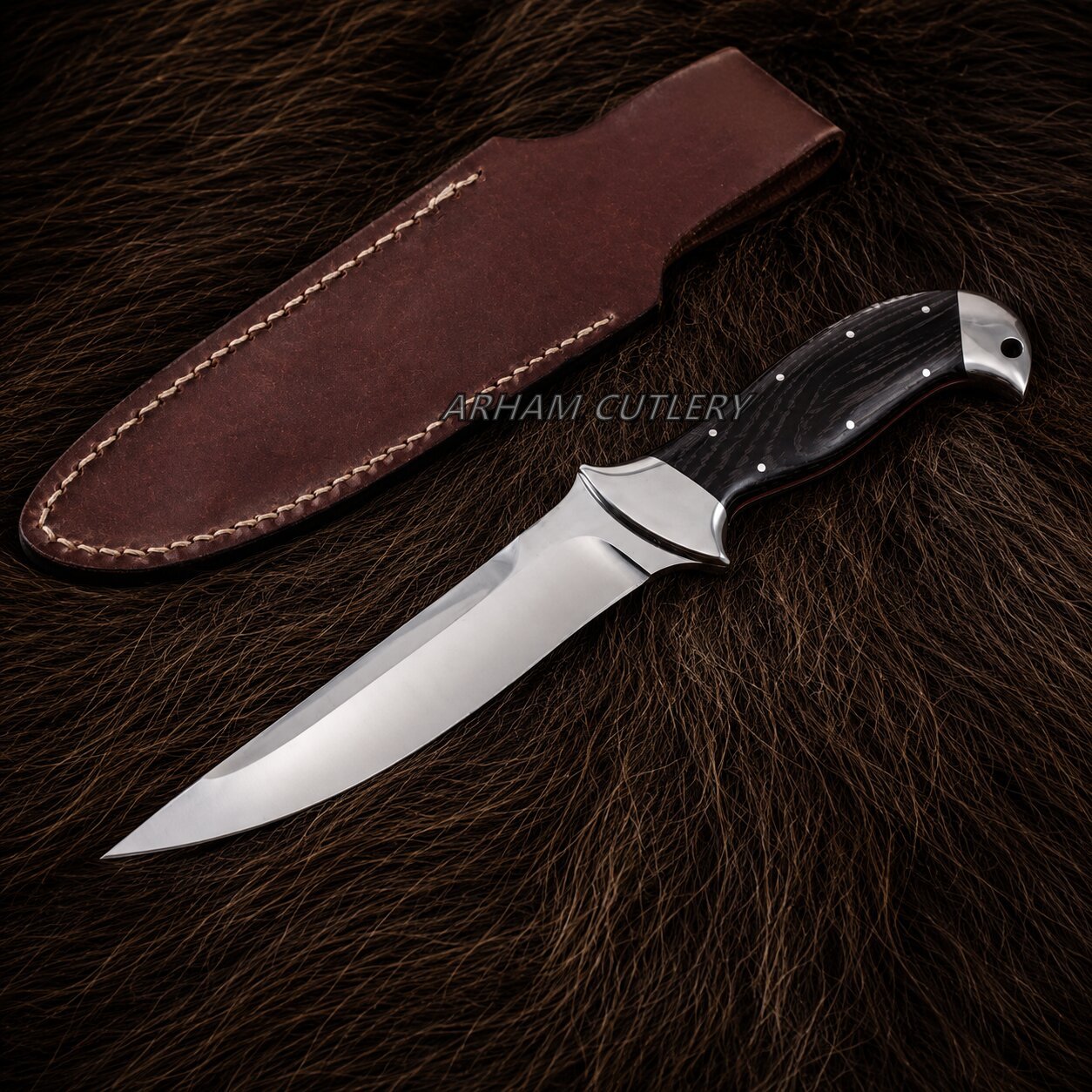 A fixed-blade knife with a polished silver blade and black handle, displayed next to its brown leather sheath on a dark brown fur background. A watermark reading 'ARKHAM CUTLERY' is visible across the center.