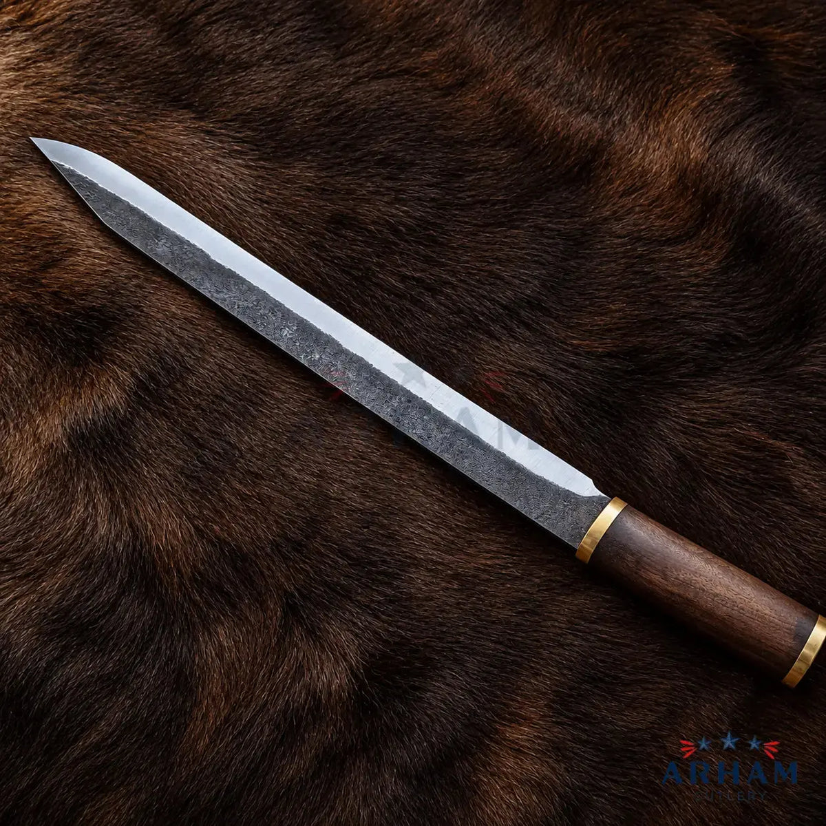 A Japanese-style kitchen knife with a patterned steel blade and a dark wooden handle, displayed diagonally on a brown fur background. The brand name 'Ariat' is visible as a watermark and logo in the bottom right corner.