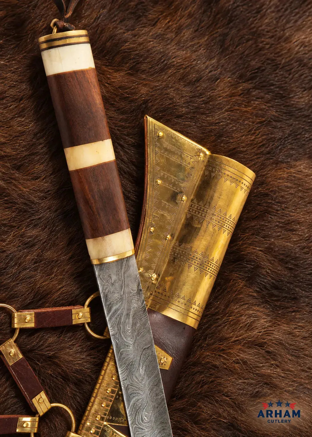 A close-up of a decorative knife and its brass sheath laid on brown animal fur. The knife handle is made of dark wood with cream inlays and a patterned steel blade.