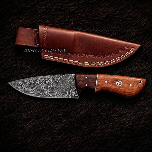 A Damascus steel fixed-blade knife with a patterned steel blade and a brown wooden handle, shown alongside its brown leather sheath on a dark textured background. The brand name 'ARHANI CUTLERY' is watermarked across the sheath.