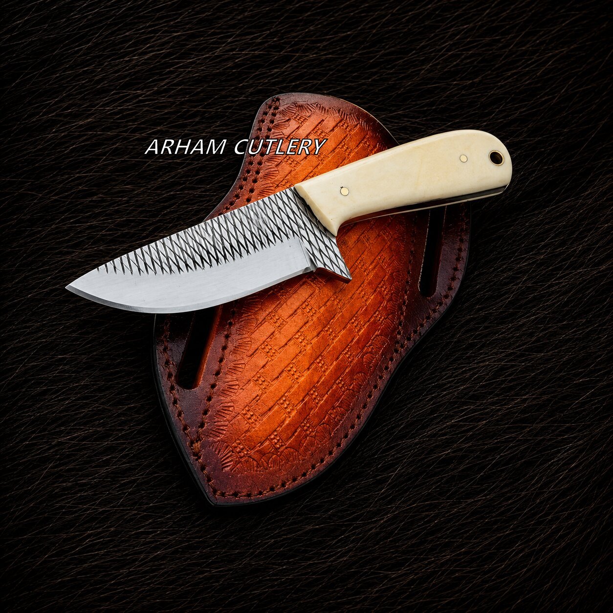 A fixed-blade knife with a patterned steel blade and cream-colored handle, resting on a brown leather sheath over a dark textured background. The text 'ARHAM CUTLERY' is overlaid on the image.