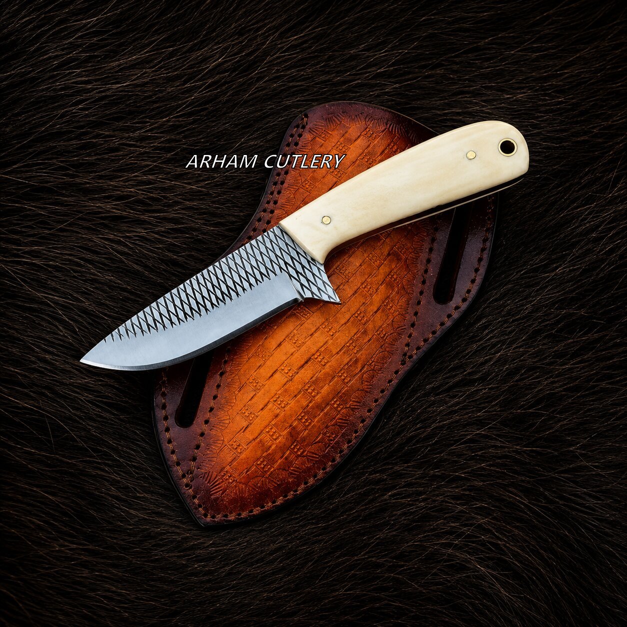 A fixed-blade knife with a textured silver blade and a cream-colored handle, resting diagonally on a brown leather sheath over a dark brown fur background. The brand name 'ARHAM CUTLERY' is printed in white text across the center.