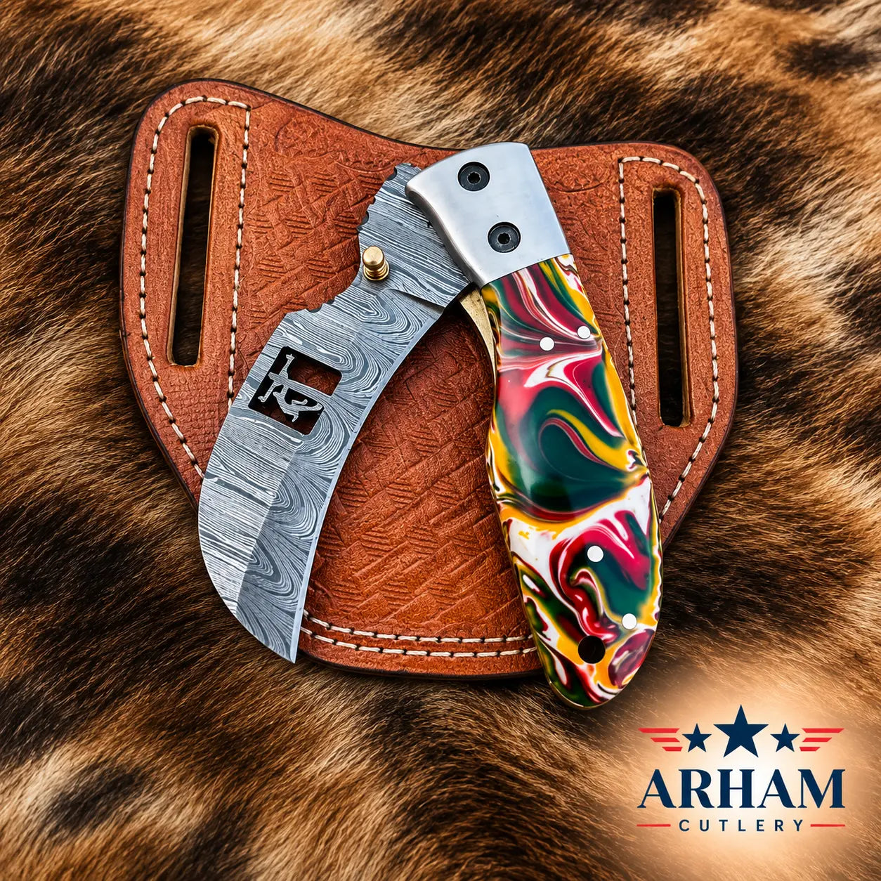 A custom folding pocket knife with a Damascus steel blade and a colorful marbled resin handle, displayed in a brown leather sheath on a brown fur background. The ARHAM CUTLERY logo is visible in the bottom right corner.