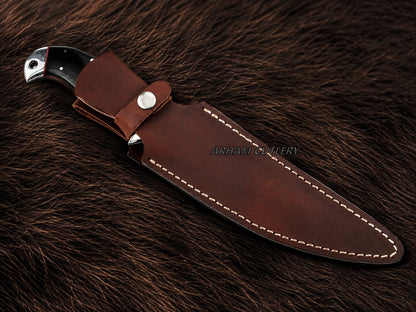 A fixed-blade knife with a dark handle, shown partially sheathed in a brown leather sheath with white stitching, placed on a dark brown fur background. The brand name 'ARSHAM CUTLERY' is printed on the leather sheath.