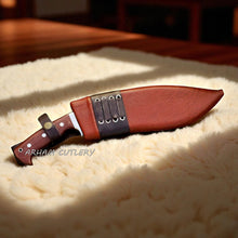 Cargar imagen en el visor de la galería, The Jungle Howl engraved Kukri machete with micarta handle and leather sheath, designed for bushcraft and outdoor use by Arham Cutlery.


