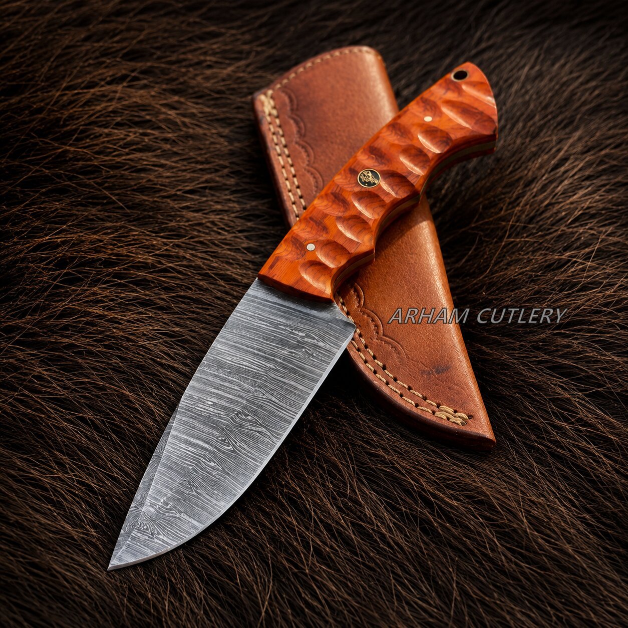A fixed-blade knife with a patterned steel blade and a textured orange-brown handle, shown partially sheathed on a dark brown fur surface. The sheath is tan leather with visible stitching.