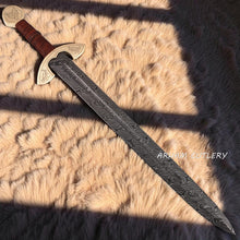 Cargar imagen en el visor de la galería, UlfSune Damascus Viking Sword with brass wolf guard, leather-wrapped handle, and back-carry red leather sheath – Arham Cutlery
