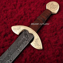 Cargar imagen en el visor de la galería, UlfSune Damascus Viking Sword with brass wolf guard, leather-wrapped handle, and back-carry red leather sheath – Arham Cutlery
