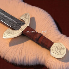 Cargar imagen en el visor de la galería, UlfSune Damascus Viking Sword with brass wolf guard, leather-wrapped handle, and back-carry red leather sheath – Arham Cutlery
