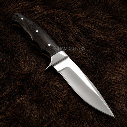 A fixed-blade knife with a polished silver steel blade and a dark brown wood handle with silver rivets, displayed diagonally on a dark brown fur background. The brand name 'ARHAM CUTLERY' is watermarked across the center.