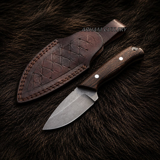 A fixed-blade knife with a dark wood handle and steel blade lies next to its stitched brown leather sheath on a dark brown fur background. The text 'ARHAM CUTLERY' is visible near the sheath.